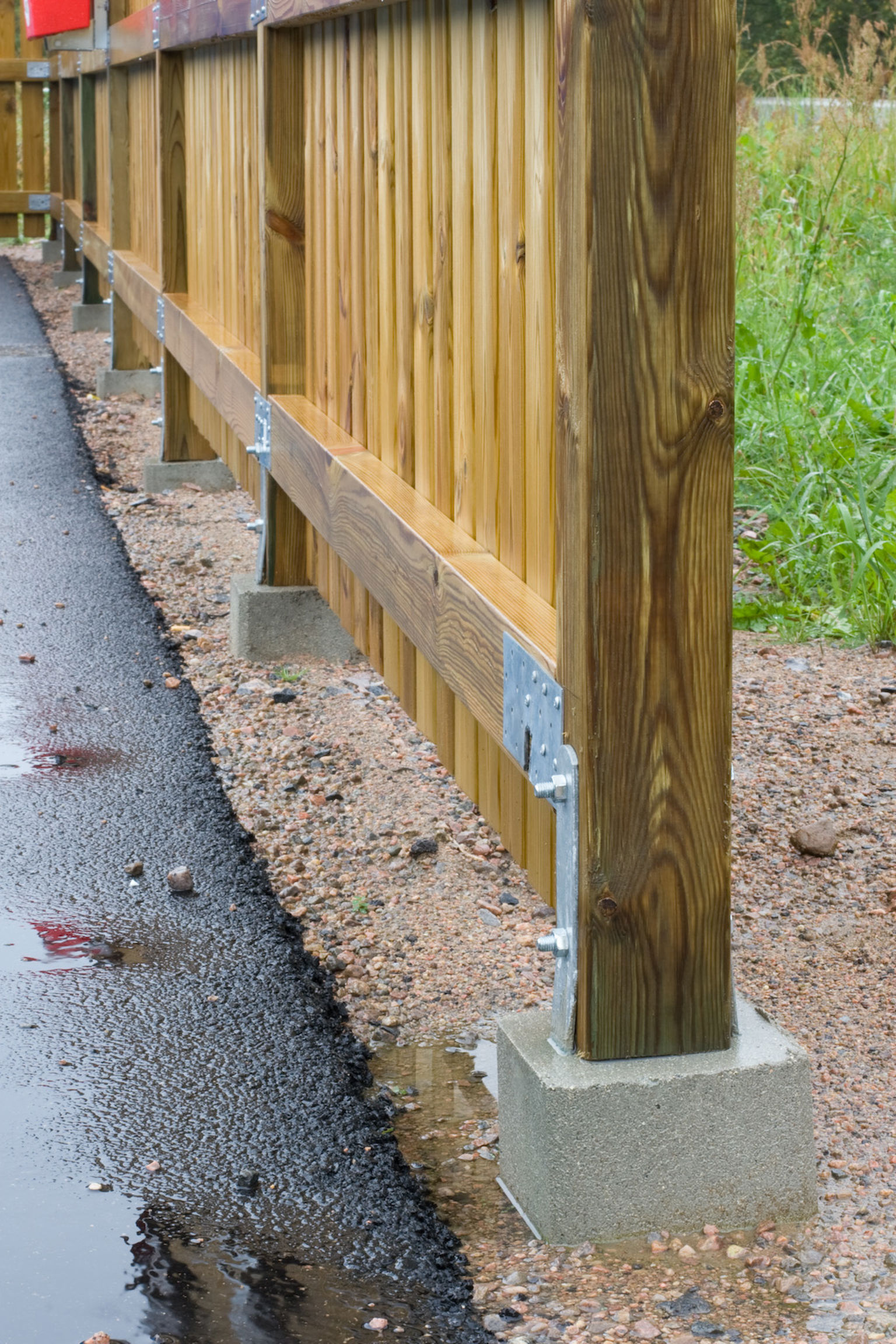 Plint med fasta järn som bär upp stolparna i ett kraftigt staket.