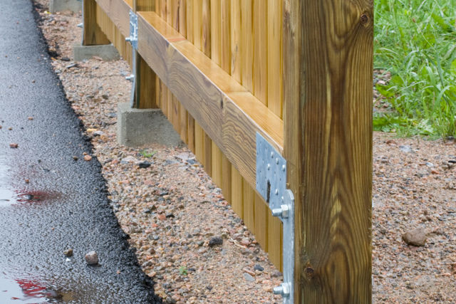 Plint med fasta järn som bär upp stolparna i ett kraftigt staket.